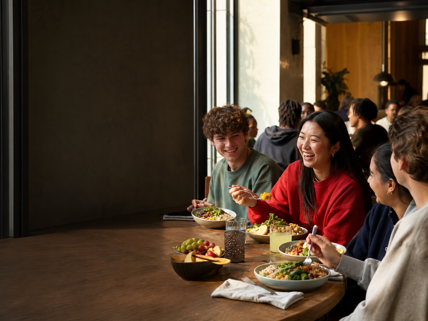 College students sharing a meal around a communal campus dining table